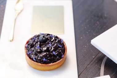 Mermer tabakta yabanmersinli turta ve fotokopi alanı olan bir restoranda altın kaşık..