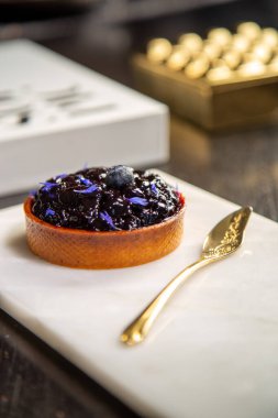 Mermer tabakta yabanmersinli turta ve fotokopi alanı olan bir restoranda altın kaşık..