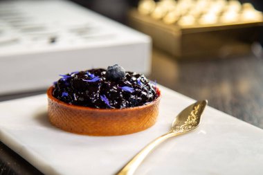 Mermer tabakta yabanmersinli turta ve fotokopi alanı olan bir restoranda altın kaşık..