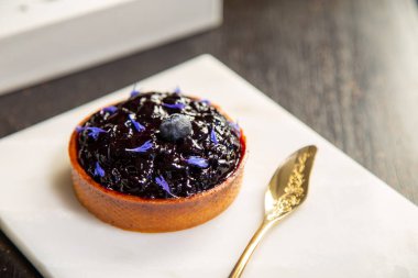 Mermer tabakta yabanmersinli turta ve fotokopi alanı olan bir restoranda altın kaşık..