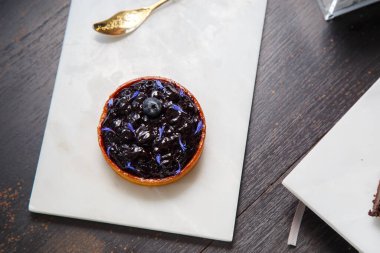 Mermer tabakta yabanmersinli turta ve fotokopi alanı olan bir restoranda altın kaşık. en üstteki görünüm.