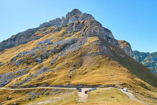 Rotsachtige bergen bedekt met herfstweide tegen de blauwe lucht — Stockfoto