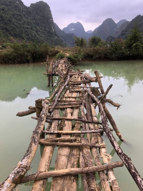 Terk edilmiş eski tehlikeli bambu köprüsü Trung Khan Bölgesi, Cao Bang Eyaleti, Vietnam 'da bir nehri geçiyor.