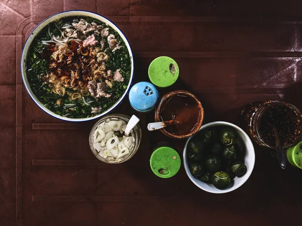 暗いテーブルの上に伝統的なフォボーでトップビュー フォーボーは ハーブ チリとベトナムの新鮮な米麺スープです ベトナムの国民料理 — ストック写真