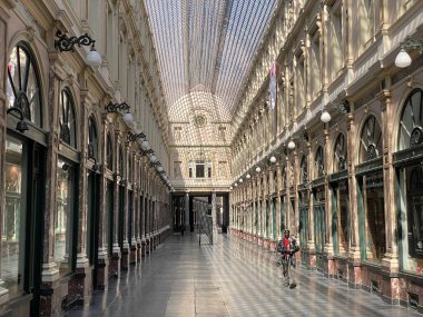 Brüksel, Belçika, 25 Nisan 2020. Hapsedilme sırasında lüks alışveriş salonu Les Galeries Saint-Hubert 'in içinde tek başına yürüyen bir kişi.