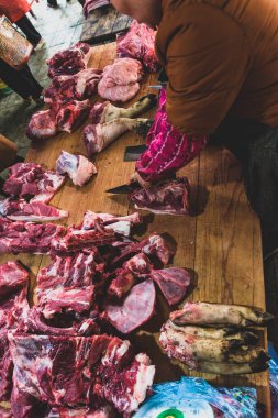 Kasabın karanlık ahşap çalışma masasında et ve bıçak var. Üst görünüm.