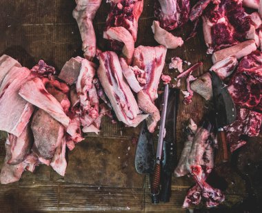 Kasabın karanlık ahşap çalışma masasında et ve bıçak var. Üst görünüm.