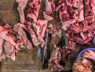 Kasabın karanlık ahşap çalışma masasında et ve bıçak var. Üst görünüm.