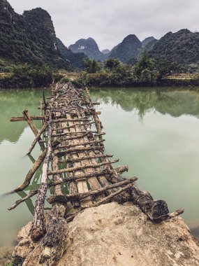 Terk edilmiş eski tehlikeli bambu köprüsü Trung Khan Bölgesi, Cao Bang Eyaleti, Vietnam 'da bir nehri geçiyor.