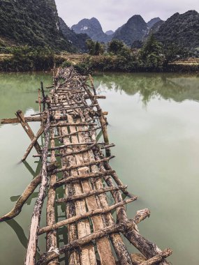 Terk edilmiş eski tehlikeli bambu köprüsü Trung Khan Bölgesi, Cao Bang Eyaleti, Vietnam 'da bir nehri geçiyor.