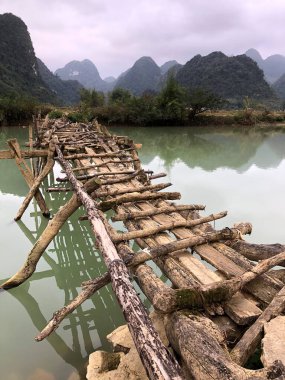 Terk edilmiş eski tehlikeli bambu köprüsü Trung Khan Bölgesi, Cao Bang Eyaleti, Vietnam 'da bir nehri geçiyor.