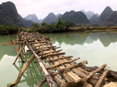 Terk edilmiş eski tehlikeli bambu köprüsü Trung Khan Bölgesi, Cao Bang Eyaleti, Vietnam 'da bir nehri geçiyor.
