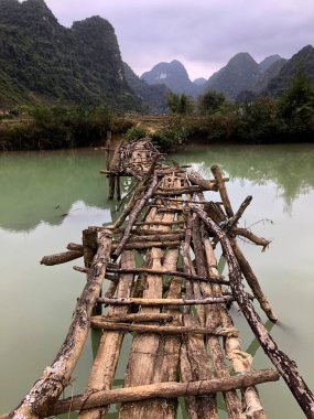 Terk edilmiş eski tehlikeli bambu köprüsü Trung Khan Bölgesi, Cao Bang Eyaleti, Vietnam 'da bir nehri geçiyor.