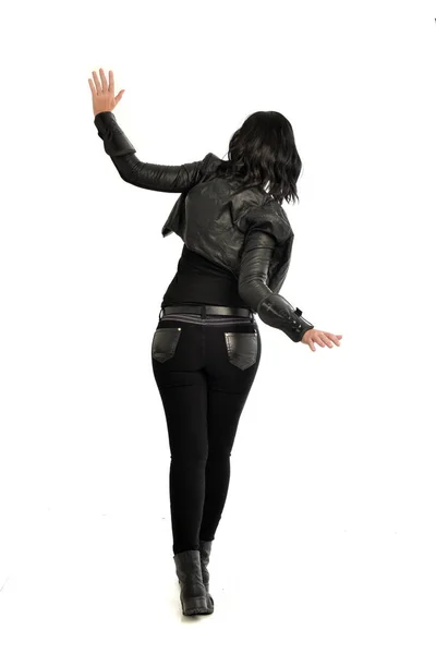 カメラから離れて直面している革の衣装を身に着けている黒い髪女の子の完全な長さの肖像画 ホワイト スタジオの背景に立ちポーズ — ストック写真