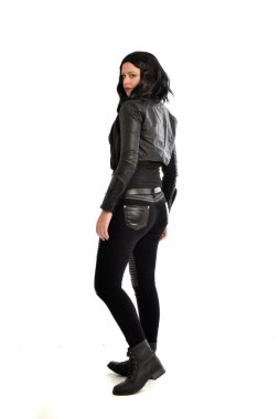 full length portrait of black haired girl wearing leather outfit, facing away from the camera. standing pose on a white studio background. clipart