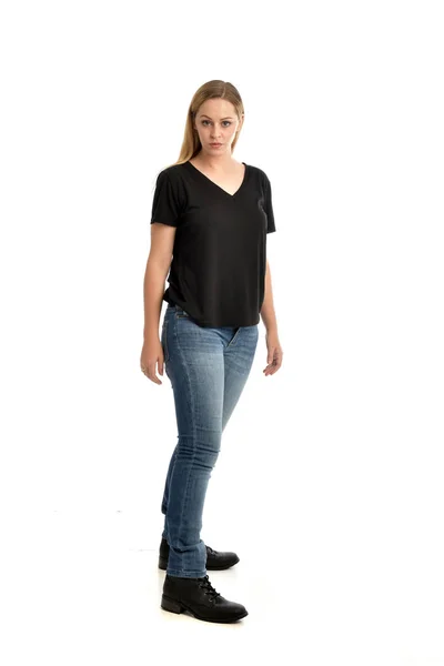 全长的肖像金发女郎身穿基本的黑色衬衫和牛仔裤 站立姿势在白色背景 — 图库照片