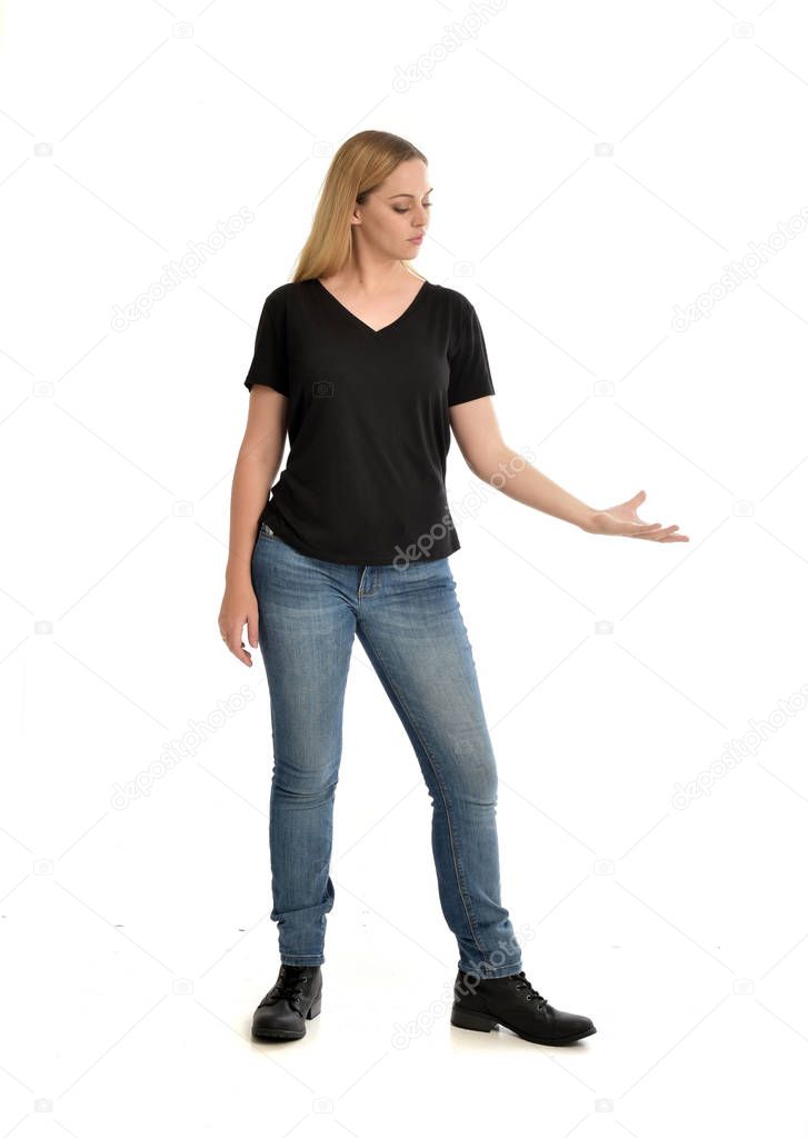 full length portrait of blonde girl wearing basic black shirt and jeans, standing pose on white background.