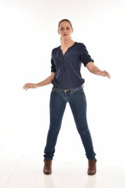 basit mavi gömlek ve pantolon giyen kız pose.isolated beyaz stüdyo arka plan üzerinde ayakta tam uzunlukta portresi.