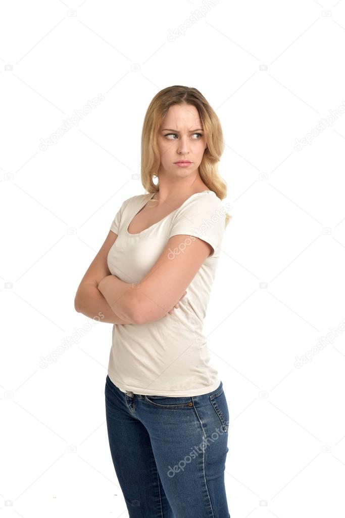 3/4 portrait of blonde girl wearing white shirt and crossing her arms. isolated on white studio background.