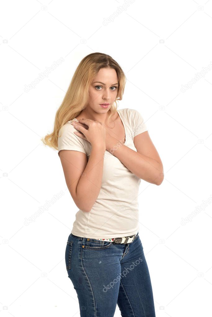 3/4 portrait of blonde girl wearing white shirt,  posing with hands touching body. isolated on white background.