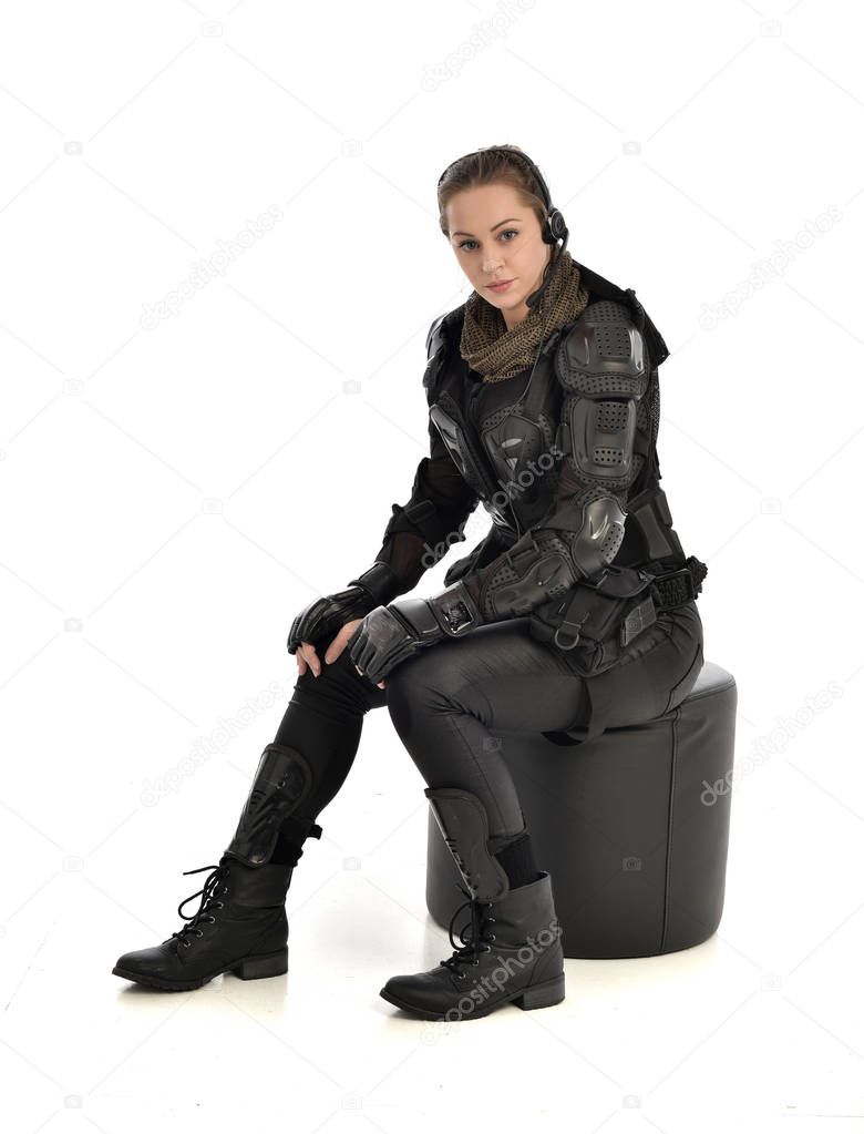 full length portrait of female wearing black  tactical armour, crouching pose, isolated on white studio background.