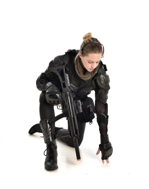 Tam boy siyah taktik zırh, CASİYE poz giyen ve bir'ın elinde, üzerinde beyaz stüdyo arka plan izole kadın portresi.