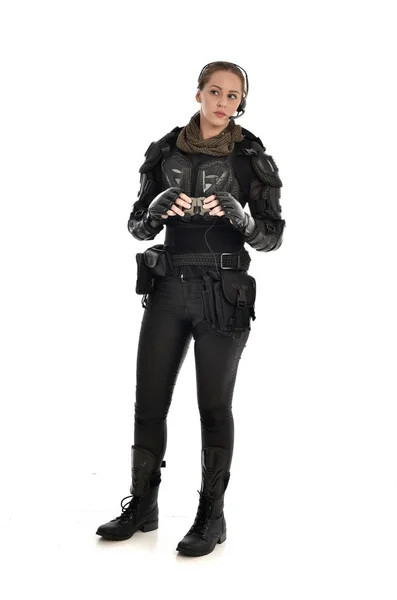 ホワイト スタジオの背景に分離された双眼鏡を保持している黒の戦術的な鎧を身に着けている女性の兵士の完全な長さの肖像画 — ストック写真