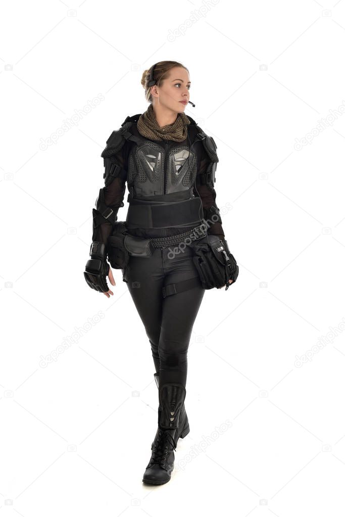 full length portrait of female  soldier wearing black  tactical armour, isolated on white studio background.