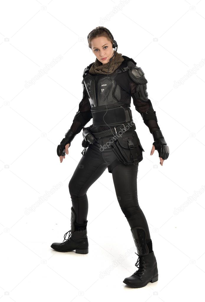 full length portrait of female  soldier wearing black  tactical armour, isolated on white studio background.