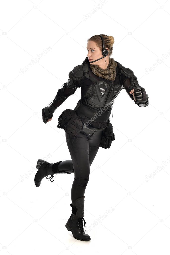 full length portrait of female  soldier wearing black  tactical armour, isolated on white studio background.