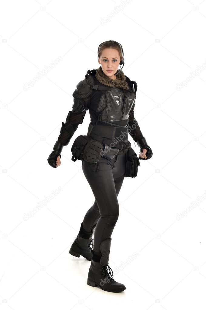 full length portrait of female  soldier wearing black  tactical armour, isolated on white studio background.