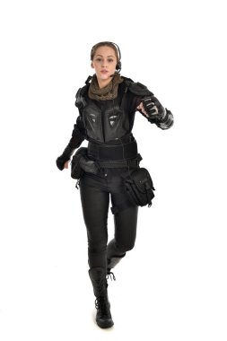 tam uzunlukta izole beyaz stüdyo arka plan üzerinde siyah taktik zırh giyen kadın asker portresi.