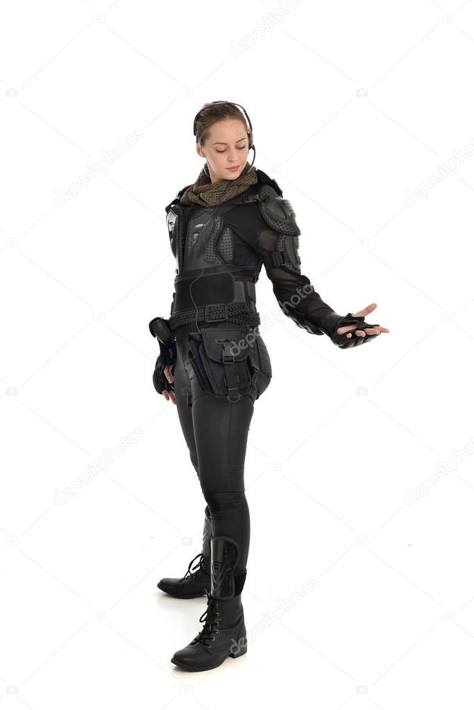 full length portrait of female  soldier wearing black  tactical armour, isolated on white studio background.