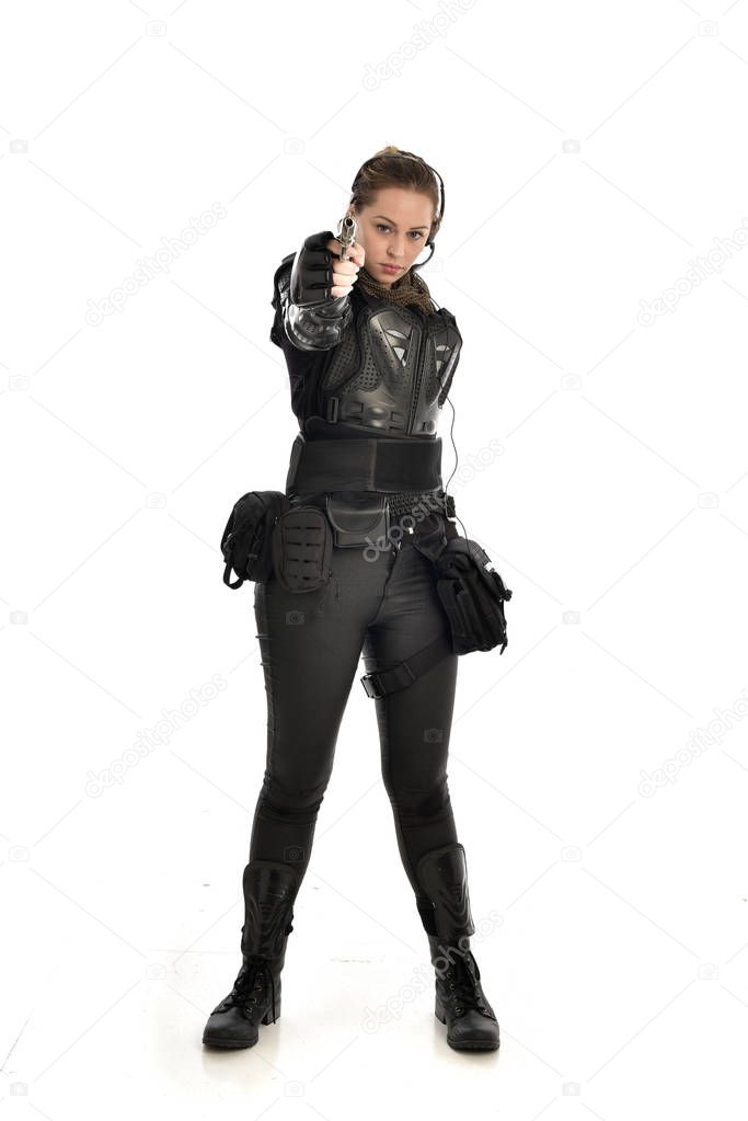 full length portrait of female  soldier wearing black  tactical armour holding a gun, isolated on white studio background.