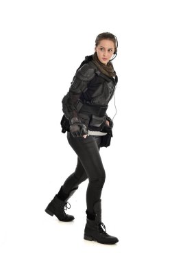 Tam boy siyah taktik zırh giyen, elinde bir bıçak, beyaz stüdyo arka plan üzerinde izole kadın asker portresi.