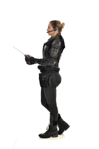 身穿黑色战术盔甲的女士兵全长画像 手持遥控 在白色演播室背景下隔离 — 图库照片