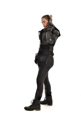 profil, ayakta siyah taktik zırh giyen kadın asker portresi tam uzunlukta beyaz stüdyo arka plan üzerinde izole.