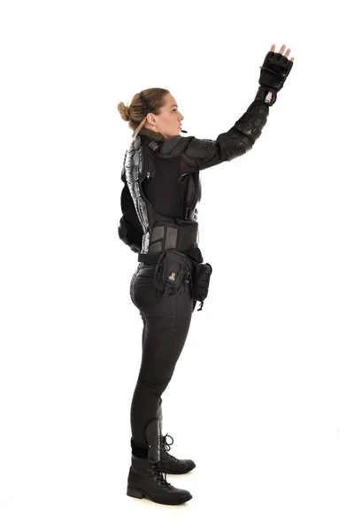 full length portrait of female soldier wearing black tactical armour,  standing in profile, isolated on white studio background. - Stock Image -  Everypixel
