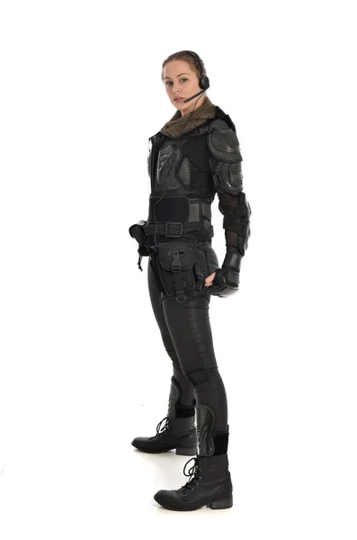 ホワイト スタジオの背景に分離されたプロファイルでは 立っている黒いの戦術的な武具を身に着けている女性の兵士の完全な長さの肖像画 — ストック写真