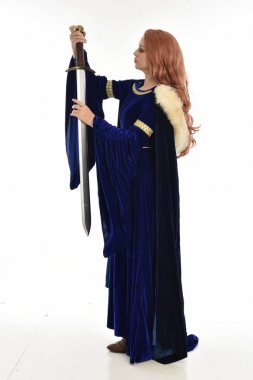 tam uzunlukta bir mavi kadife Ortaçağ elbisesi ve kürk Pelerin giyen kadın uzun saçlı portresi. yan profil, beyaz arka plan üzerinde izole ayakta poz.