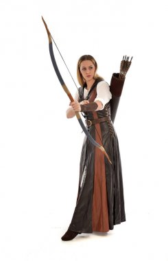 tam uzunlukta ok ve yay ile kahverengi Ortaçağ fantezi kıyafet giyen kadın portresi. Beyaz stüdyo arka plan üzerinde ayakta poz.