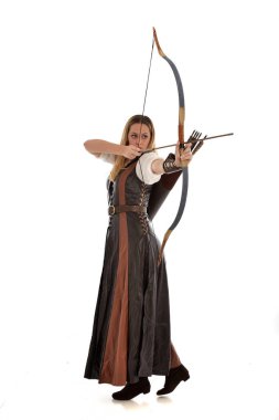 tam uzunlukta ok ve yay ile kahverengi Ortaçağ fantezi kıyafet giyen kadın portresi. Beyaz stüdyo arka plan üzerinde ayakta poz.