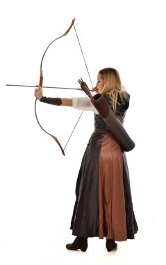 tam uzunlukta ok ve yay ile kahverengi Ortaçağ fantezi kıyafet giyen kadın portresi. Beyaz stüdyo arka plan üzerinde ayakta poz.