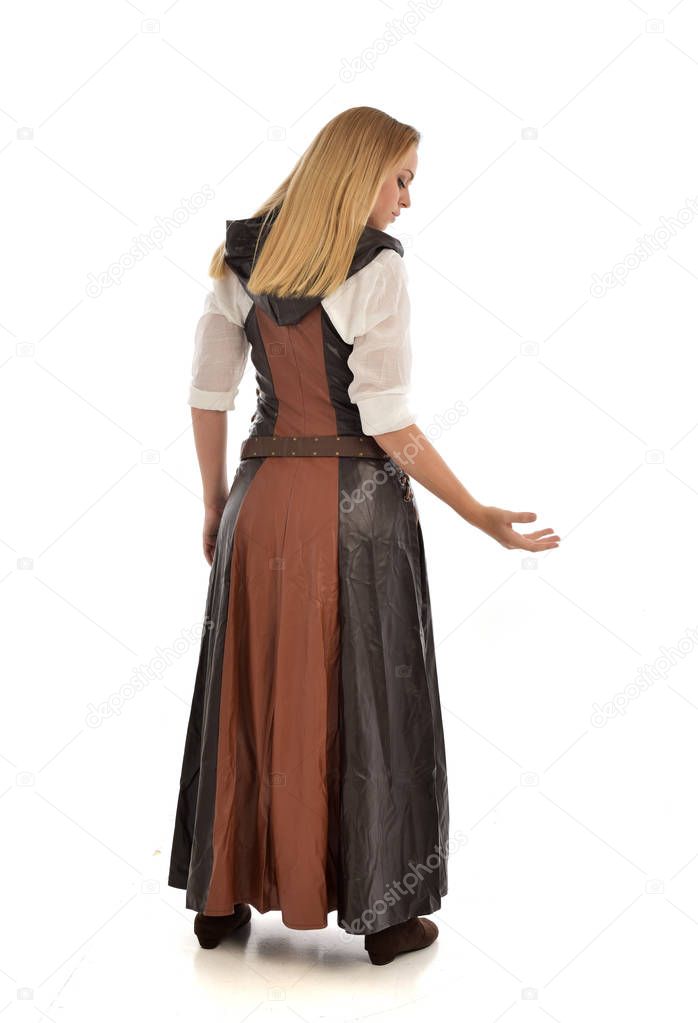 full length portrait of blonde girl wearing  brown leather fantasy outfit, standing pose with the back to the camera. isolated on white studio background.