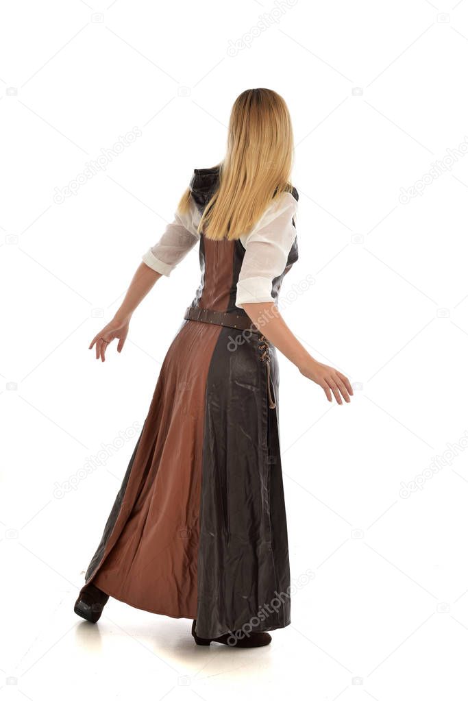 full length portrait of blonde girl wearing  brown leather fantasy outfit, standing pose with the back to the camera. isolated on white studio background.