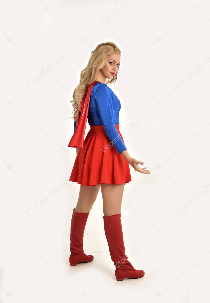 full length portrait of pretty girl wearing super hero costume, standing pose, isolated on white studio background.