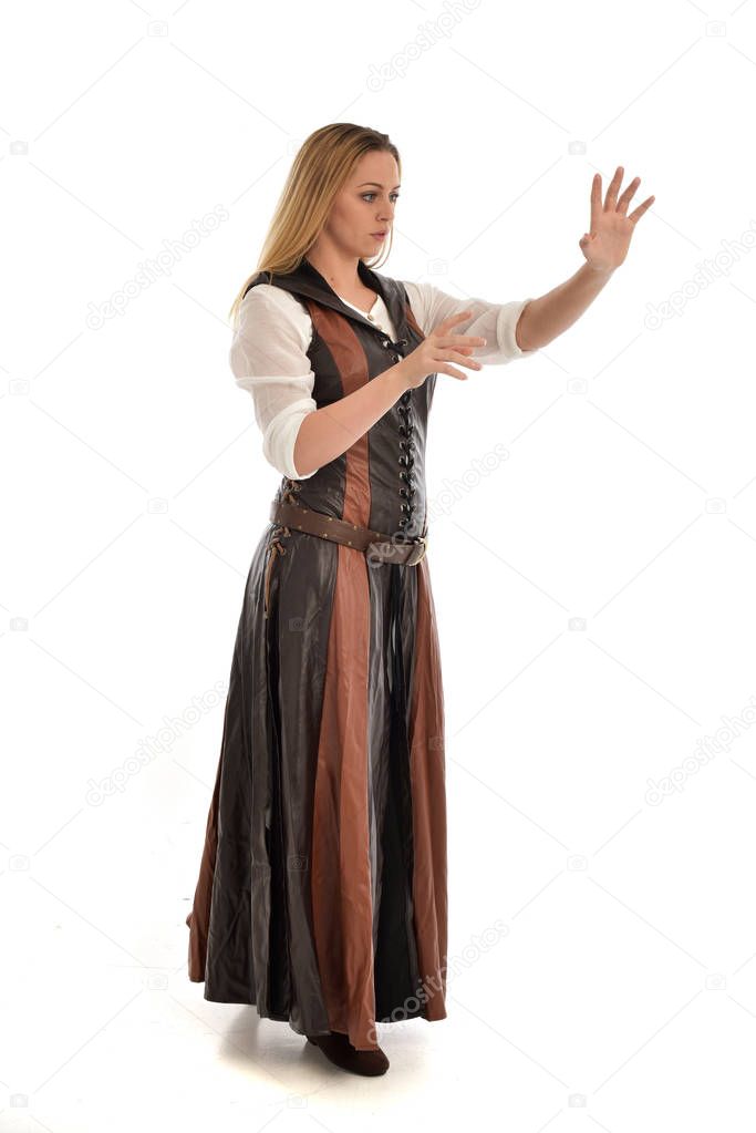 full length portrait of girl wearing brown leather medieval costume, standing pose, isolated on white studio background.