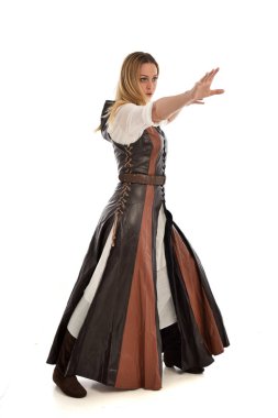 Beyaz stüdyo arka plan üzerinde izole kahverengi deri ortaçağ, ayakta poz, giyinen kız portresi tam uzunlukta.