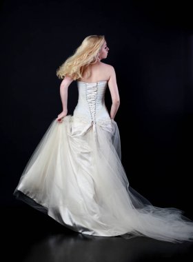 tam uzunlukta portre beyaz model giyen gelin topu cüppe, ayakta poz siyah arka plan üzerine.