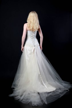 tam uzunlukta portre beyaz model giyen gelin topu cüppe, ayakta poz siyah arka plan üzerine.
